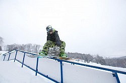 A snowboarder rides a rail at Sir Sam's terrain park