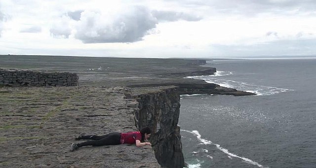 Megan lying at the edge of a cliff on the Aran Islands, at the same spot where her father many years before had decided to spend the rest of his life with her mother