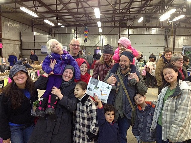 Lise Fines (left), a member of the Salaam Peterborough sponsor group, with the Alkhalaf family and members of three other families in the sponsor group at the Peterborough Farmers' Market in January (photo: Rick Fines, courtesy of Lise Fines)