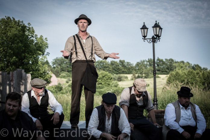 Ryan Hollyman (standing) is "The Man", the audience's guide and host for the play; also pictured: Josh Butcher, Geoff Hewitson, Mac Fyfe, Ken Houston, and Mark Hiscox (photo: Wayne Eardley, courtesy of Wayne Eardley Photography)
