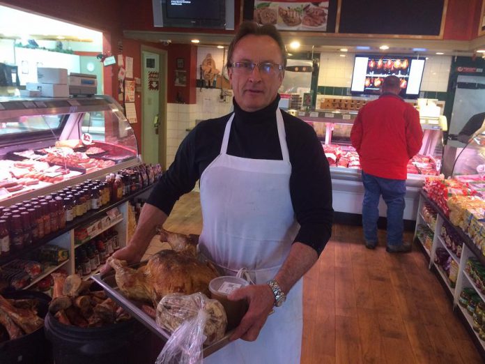 Franz Roessl, owner of  Franz's Butchershop and Catering, holds up a cooked turkey with stuffing and gravy. Franz will sell over 1,000 turkeys this holiday season. (Photo: Eva Fisher / kawarthaNOW)