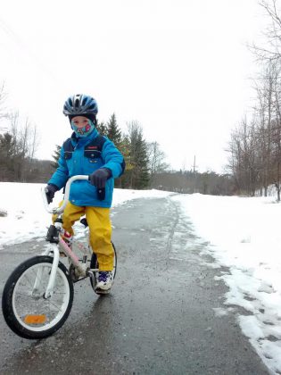 Beck Akiyama wears a warm coat, waterproof pants, winter gloves, and a balaclava to stay warm and dry while biking along the Rotary Trail in East City, Peterborough (photo courtesy of GreenUP)