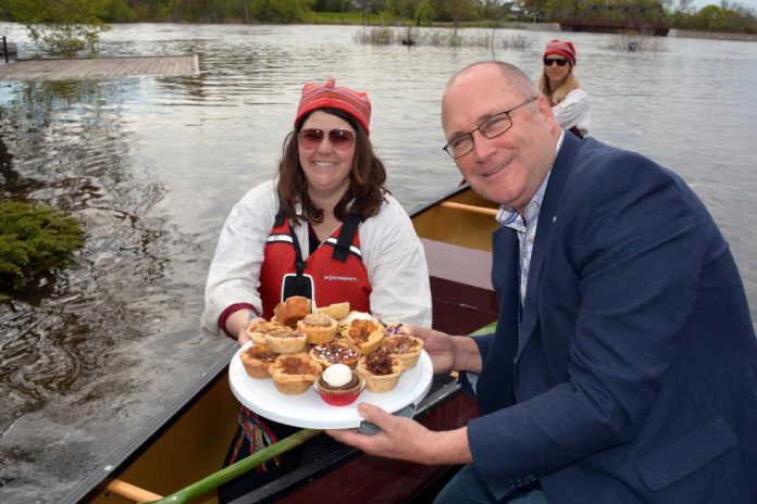 The tarts were ceremoniously paddled in by staff from the Canadian Canoe Museum, who handed them off to Stu Harrison, General Manager of the Peterborough Chamber of Commerce. (Photo: Eva Fisher / kawarthaNOW)
