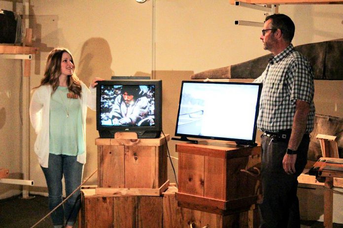 Devon Bathurst, Redevelopment Project Officer at The Canadian Canoe Museum, with one of the museum's old cathode ray tube televisions. David Feeley stands beside one of the 14 flat-screen televisions donated by Cogeco that will now be used at the museum's exhibits. (Photo: The Canadian Canoe Museum)