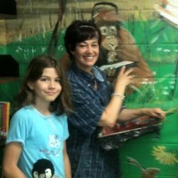 Silvia started out painting one wall of the library at St. Paul’s. The next thing she knew, the mural had spread out across the entire room. (Photo by Carol Lawless)