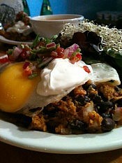 Black bean enchiladas topped with sour cream, salsa, and a fried egg (photo: Planet Bakery)