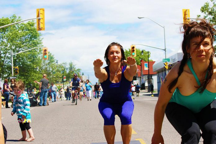 A woman practices yoga on the street at Open Streets in Thunder Bay. Peterborough's first open streets events, Peterborough Pulse, kicks off at 9 a.m. on July 18. Peterborough will open up selected city streets to a variety of fun activities and events, creating a vibrate, playful, and active car-free corridor between Peterborough's downtown and the Saturday Farmers' Market. (Photo: CNW Group/Open Streets Toronto)