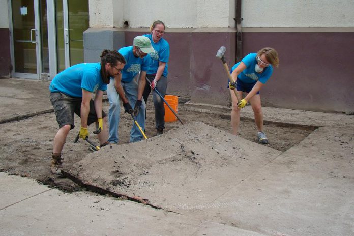 In Peterborough's first Depave Paradise project in June 2014, volunteers remove asphalt in front of the Brock Mission to prepare to transform the space into a garden