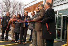 Cutting the ribbon at the official opening of Peterborough's new Long & McQuade store (from left to right): CEO & President Steve Long, councillor Keith Riel, MP Maryam Monsef, MPP Jeaf Leal, Bud Monahan, unidentified, Warden J. Murray Jones, councillor Dave Haacke