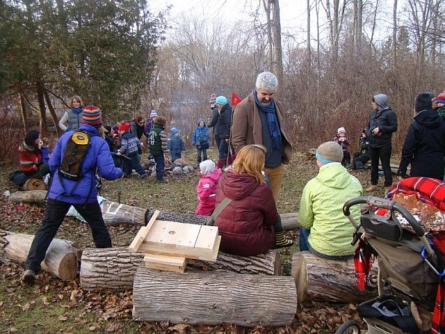 Families gather around the fire at GreenUP Ecology Park enjoying cider and roasted marshmallows while learning about wildlife in winter