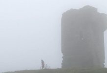 Megan Murphy with her father's bicycle at the Cliffs of Moher in County Clare in a scene from "Murphy's Law", the documentary of her journey across Ireland
