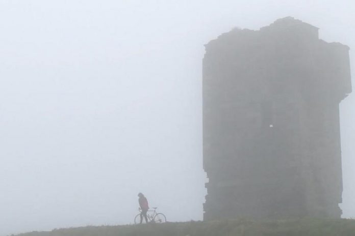 Megan Murphy with her father's bicycle at the Cliffs of Moher in County Clare in a scene from "Murphy's Law", the documentary of her journey across Ireland