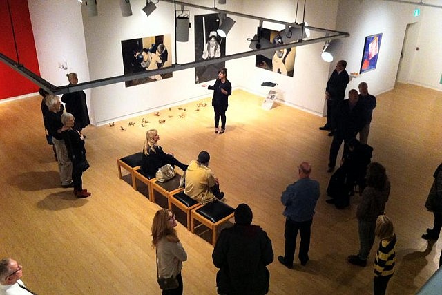 Art Gallery of Peterborough curator Fynn Leitch at the opening reception of the current exhibits at the gallery, with works by Jamelie Hassan and Andy Warhol seen on the walls (photo: Elizabeth Fennell)