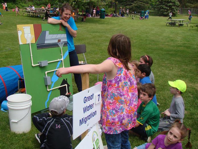 During the 2015 Peterborough Children's Water Festival, a GreenUP Ecology Park educator at The Great Water Migration interactive activity centre demonstrates how children can reduce storm water runoff and improve the quality of water that goes down our drains