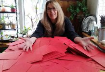 Author Mary Giuffre, who rescued Ruby from a puppy mill, with red envelopes representing letters she hopes people send during the Valentine's Day letter campaign to shut down puppy mills