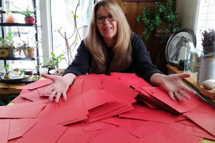 Author Mary Giuffre, who rescued Ruby from a puppy mill, with red envelopes representing letters she hopes people send during the Valentine's Day letter campaign to shut down puppy mills