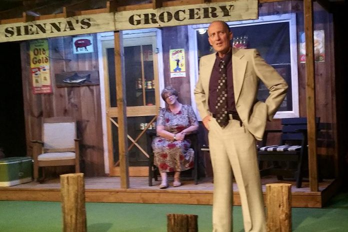 John Carter as fishing derby organizer Kirk Douglas and Deb Crossen as grocery store owner Sienna in The Hall's Bridge Players' production of Norm Foster's "The Great Kooshog Lake Hollis McCauley Fishing Derby" (photo: Keith Smith / The Hall's Bridge Players)