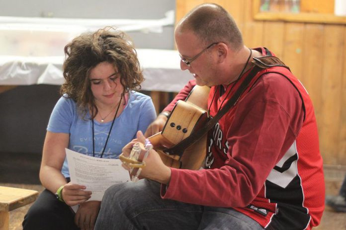 Eric Petersiel playing guitar with his daughter Lilah, a neuroblastoma survivor, at the annual James Fund Neuroblastoma Family Retreat. The 9th annual Nexicom James Fund Golf Classic on June 6 raises funds to support families attending the retreat, where kids with neuroblastoma can play at camp and their families can come together to share their struggles. (Photo: Kristian Partington)