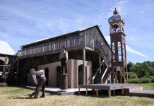 Part of the set for 4th Line Theatre's original production The Hero of Hunter Street at the Winslow Farm in Millbrook, with a reproduction of the downtown Peterborough clock tower in the background (photo: Jeannine Taylor / kawarthaNOW)