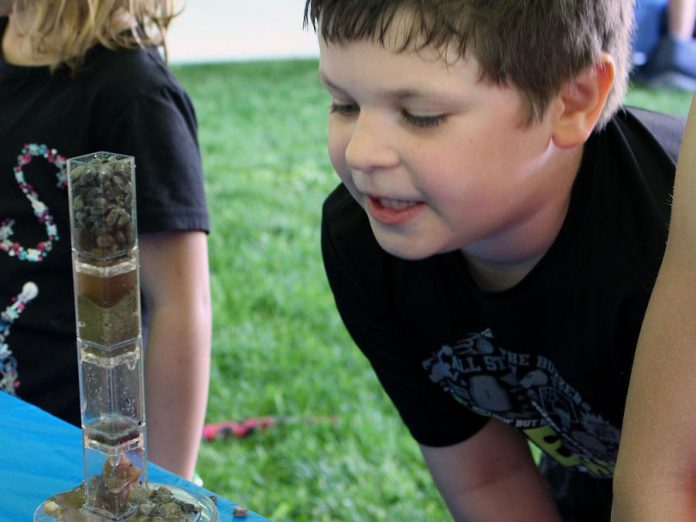 An attendee of the Peterborough Children’s Water Festival participates in a Wonders of Water activity that guides children through building a simulated cross section of soil layers to visualize how water is filtered as it flows underground. The new Wonders of Water pilot program will extends learning from the festival throughout the academic school year to a larger age range. (Photo: GreenUP)