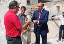 MPP Jeff Leal and Mayor Daryl Bennett handle the time capsule, a sealed glass jar buried in 1864 at the site of the old Peterborough County Jail.