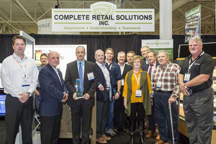 Complete Retail Solutions accepting the Best of Show award from the Canadian Federation of Independent Grocers (CFIG) at Grocery Innovations Canada. Left to right: Dan McMurray (Executive VP Southern CaseArts), Mike Guy (Woodarts), Thomas A. Barlow (President & CEO CFIG), Greg Butler (President, CRS/Pan-Oston), Bennet Foster (President, TechniLite Systems), Stephen Philpott (President, Woodarts), Glen Bonner (VP sales, CRS/Pan-Oston), Phil Golsby (sales, Pan-Oston), Donna O'Brien (VP Sales, Technilite), Dave Powell and Peter Cavin of CFIG, Pete Scanlon (Sales and Marketing CRS/Pan-Oston), and Neil Trineer (VP Sales and marketing Maintech). (Photo courtesy of CRS/Pan-Oston)