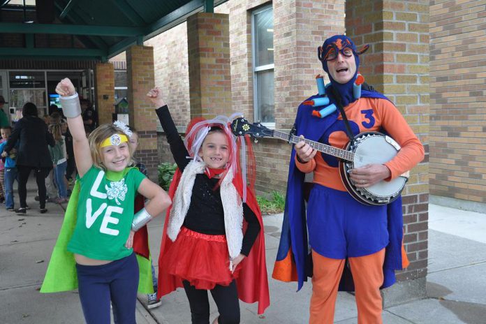 Children from St. Alphonsus Catholic Elementary School, dressed as ECO-Superheros, celebrate the kick off of Car Free Wednesdays with Cool Captain Climate before joining their school on a group walk to St. Alphonsus Church. (Photo: Lindsay Stroud, GreenUP Manager of Transportation and Urban Design Programs)