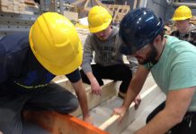 Fleming College Carpentry Techniques students Daniel Widdis, Carter Clark, and Benjamin Wright working on a wall frame destined for the new Peterborough County Agricultural Heritage Building at Lang Pioneer Village in Keene (photo: Paul Rellinger / kawarthaNOW)