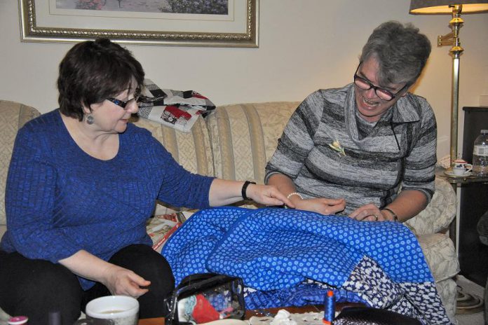 Colleen Carruthers, who is coordinating the 150 Canadian Women Quilt project for the Peterborough Women's Business Network, with fellow quilter Debbie Fisico. (Photo: Jeanne Pengelly / kawarthaNOW)