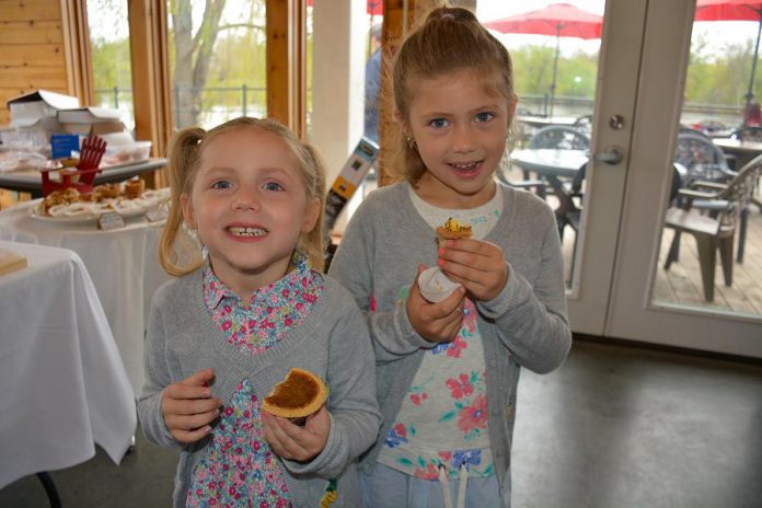 The Kawarthas Northumberland Butter Tart Tour is the biggest of its kind in Ontario, with over 50 participating bakeries. At an event at the Silver Bean Cafe launching the fifth year of the tour, Elle and Olivia sample the Goose Butter Tart from Ste. Anne's Spa and the Nanaimo Bar Butter Tart from the Magic Rolling Pin. (Photo: Eva Fisher / kawarthaNOW)