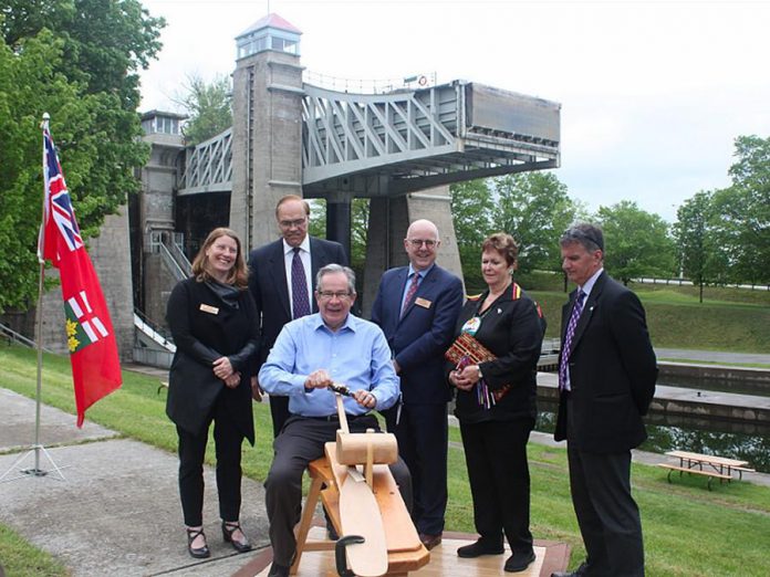 At the event announcing $9 million in provincial funding for the new canoe museum, Peterborough MPP Jeff Leal is invited to carve a canoe paddle, symbolic of the journey to the new facility to be built beside the Peterborough Lift Lock. Also pictured are representatives from The Canadian Canoe Museum, Peterborough Mayor Daryl Bennett, Curve Lake First Nation Chief Phyllis Williams, and Peterborough County Warden Joe Taylor. (Photo: The Canadian Canoe Museum)