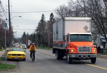 A cyclist passes a parked car on River Road in Peterborough, while the driver of a truck gives ample space when passing the cyclist. Giving a minimum of one metre of space when passing a cyclist is the law. The one-metre cushion is designed to keep everyone safe on our roads. (Photo: Lindsay Stroud)