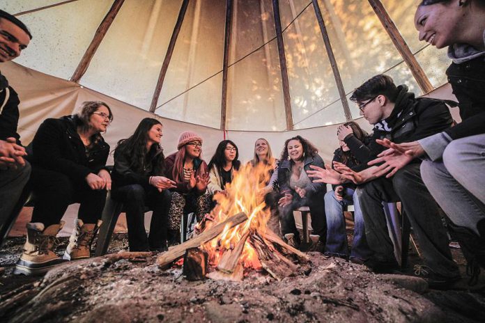 Students sit in a tipi on Symons Campus at Trent University as they listen to a professor. Trent University has consolidated and renamed its indigenous studies program as the Chanie Wenjack School for Indigenous Studies, in honour of the nine-year-old Anishinaabe boy who died from exposure when trying to get home after running away from a residential school in Kenora in 1966. (Photo: Trent University)