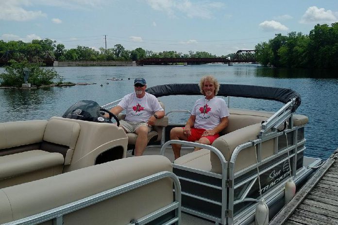 Moe Grant and Lloyd Graham of Pedal 'n' Paddle in the pontoon boat they've added to their fleet of canoe, kayak, bicycle, and pedal boat rentals at The Boat House at Millennium Park.