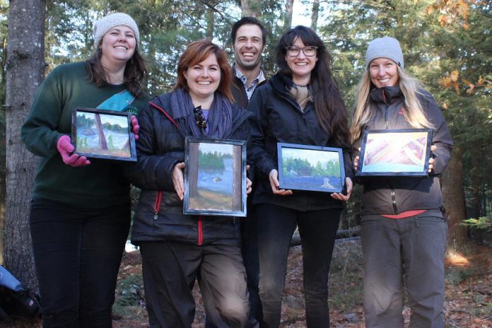 Participants at the April workshop holding their landscape paintings, with local artist Paul Teleki in the background. (Photo courtesy of The Canadian Canoe Museum /  The Land Canadian Adventures)