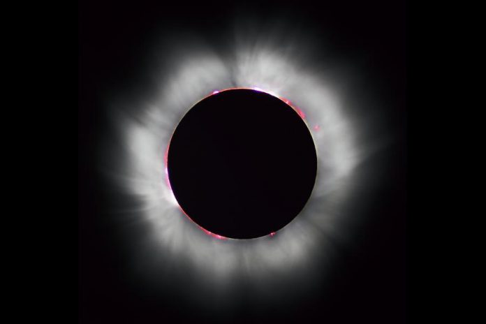 As seen in this 1999 total solar eclipse, the moon completely obscures the sun's disk, making solar prominences (in red) visible as well the sun's corona. (Photo: Luc Viatour)