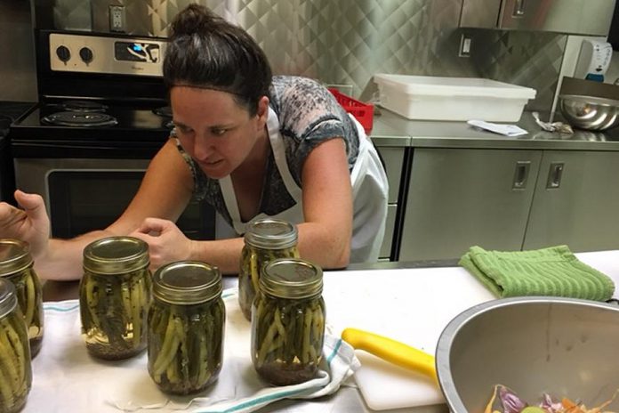 Community Food Cultivator Jillian Bishop checks the seal on some newly canned jars of pickled beans at a previous Nourish workshop. (Photo: Nourish Project)