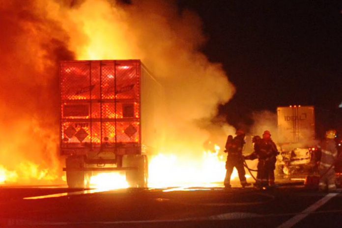 Firefighters battle the blaze caused when a tractor trailer collided with two cars on August 3 near Port Hope.