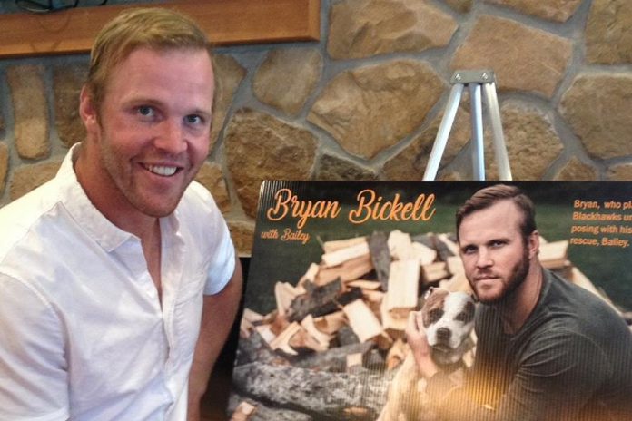 Retired Chicago Blackhawks forward and two-time Stanley Cup champion Bryan Bickell with his entry in the Peterborough Humane Society's 'Shelter Shots' fundraising calendar at a launch event at Ricky's All Day Grill on September 26, 2017. Bickell, who posed with his rescue pit bull Bailey in a photograph donated by Peter Nguyen, is one of several past and current NHL players and other sports figures who appear with their rescue cats and dogs in the $20 calendar, all sales of which will go directly to support the Humane Society's rescue efforts. (Photo: Paul Rellinger / kawarthaNOW)