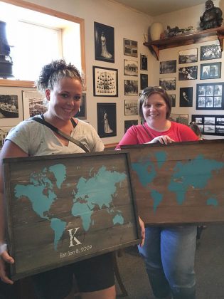 Workshop participants show their designs from the workshop at the Black Horse Pub. There are a multitude of options, ranging from family surname signs with the option for an "established" date to a world map to sayings from poems and songs. (Photo: Anchor & Co.)