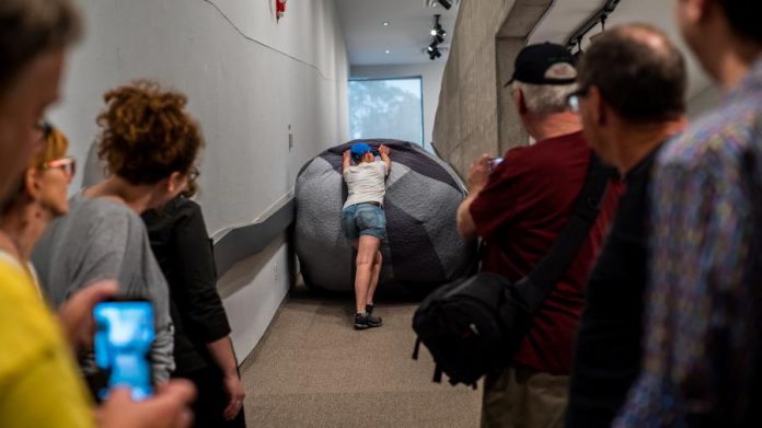 Becky Welter-Nolan during her performance of 'Pushing It' at the Art Gallery of Peterborough. The sculpture, named 'Rocky III', is 6 feet in diameter and weighs 200 pounds. (Photo: Matt and Steph, courtesy of the Art Gallery of Peterborough)