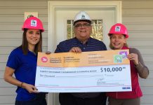 Habitat for Humanity Peterborough & Kawartha Region Resource Development Manager Emily Ferguson and CEO Sarah Burke accept a cheque from Canada Post Local Area Manager Eugene Adamo on the build site of Habitat's current local project at 505 Wellington Street in Peterborough. (Photo: Habitat for Humanity Peterborough & Kawartha Region)