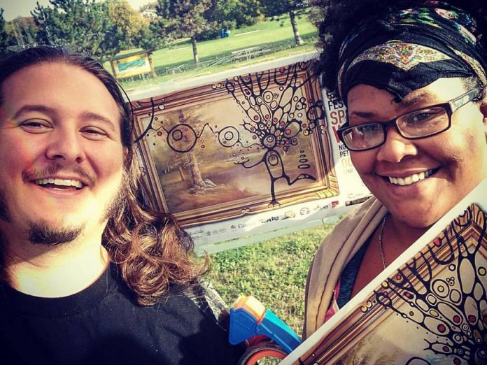 Jon Hedderwick, festival director and member of the Peterborough Poetry Slam Collective, with Elizabeth Jenkins putting up posters for this year's Canadian Festival of Spoken Word. (Photo: Jon Hedderwick / Facebook)