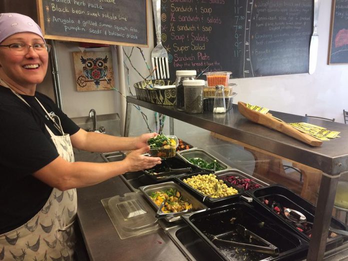 Judy Cameron, an employee at By the Bridge, serves a salad with hokkaido and summer squash. (Photo: Eva Fisher)