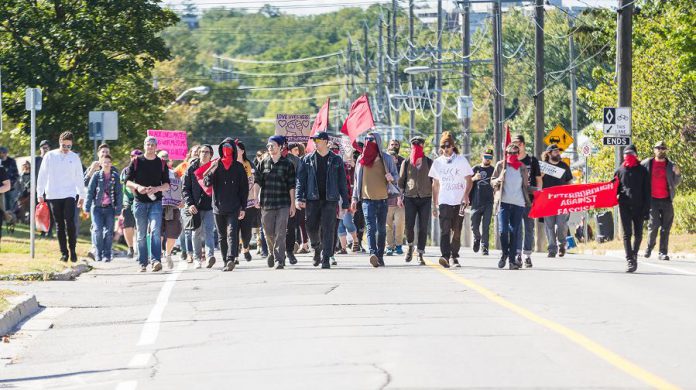 While the vast majority of participants at the anti-hate rally in downtown Peterborough on September 30, 2017 were local residents who protested peacefully, some of the protestors disguised their identities and some came from outside the area, including 22-year-old William October of Toronto who has been charged with assault and obstruct peace officer. (Photo: Linda McIlwain / kawarthaNOW.com)