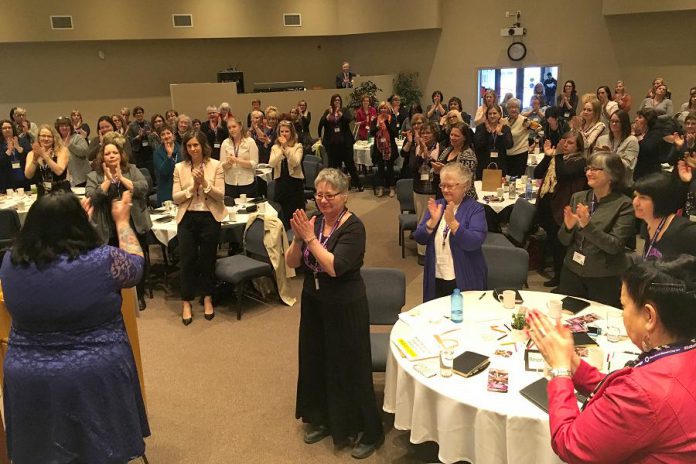 Feminist comic and actor Candy Palmater (left, with her back to the camera) was one of the keynote speakers at Peterborough's first International Women's Day Conference on March 8, 2017 and received  a standing ovation from the 150 women attending the sold-out event, including Louise Racine of Thirteen Moons Wellness (centre) who was the driving force behind the inaugural conference. (Photo: Jeanne Pengelly / kawarthaNOW.com)