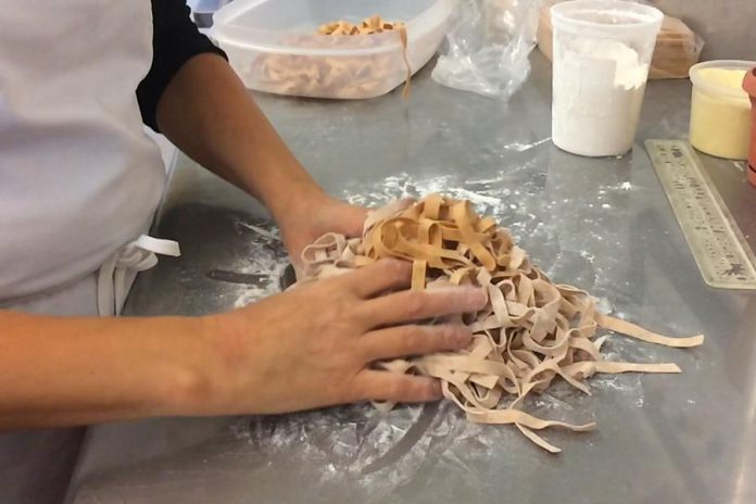 Anna Lisa Breese of The Pasta Shop tosses a fresh batch of tomato basil pasta. (Photo: Eva Fisher / kawarthaNOW.com)