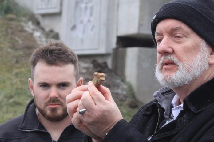At the November 14th commemorative ceremony, project archeologist Dr. Ronald Williamson displays a clay pipe found during archaeological investigations prior to the construction of Highway 407 East Phase 2. The investigation found around 150,000 items, mainly pottery fragments, but also clay pipes and beads made of sea shells from the Atlantic coast and rocks found only in Quebec. (Photo courtesy of Blackbird Infrastructure Group)