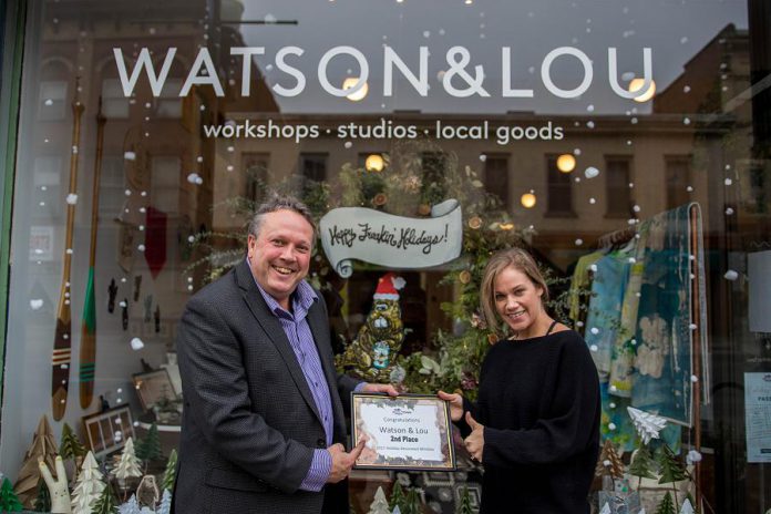 Erin Watson, co-owner of Watson & Lou, receives her second place award in the annual Holiday Window Contest from DBIA Executive Director Terry Guiel. (Photo: Peterborough DBIA)