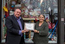 Peterborough DBIA Executive Director Terry Guiel presents The Toy Shop owner Jean Grant with her first place prize in the annual Holiday Window Contest, which was judged by little brothers and sisters from Big Brothers Big Sisters of Peterborough. Grant is donating her $300 prize to the Salvation Army Toy Drive. (Photo: Peterborough DBIA)